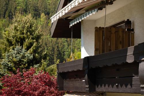 a porch of a house with trees and bushes at Hotel Petra in Baiersbronn