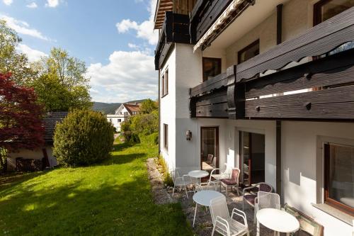 a patio with tables and chairs on the side of a house at Hotel Petra in Baiersbronn