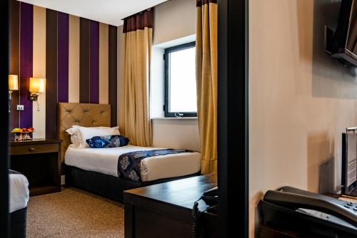 a hotel room with a bed and a window at Grand Sapphire Hotel & Banqueting in Croydon