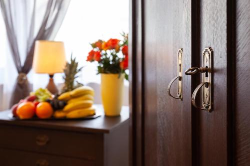 a table with bananas oranges and a vase of flowers at Hotel Petra in Baiersbronn