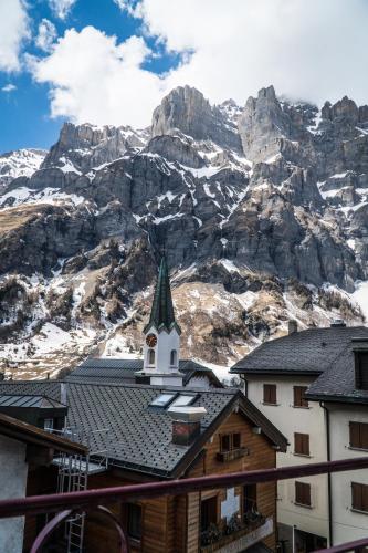 a church in front of a mountain with snow at Weisses Rössli in Leukerbad