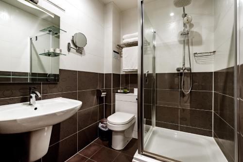 a bathroom with a sink and a toilet and a shower at Grand Sapphire Hotel & Banqueting in Croydon