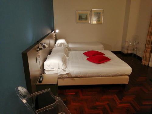 a bedroom with a bed with red pillows on it at Locanda Giustini in Assisi