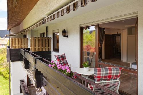 a porch of a house with a table and chairs at Hotel Petra in Baiersbronn
