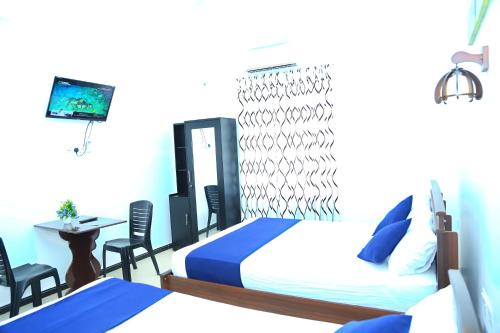 a bedroom with two beds and a table and chairs at Blue Diamond Resort in Trincomalee