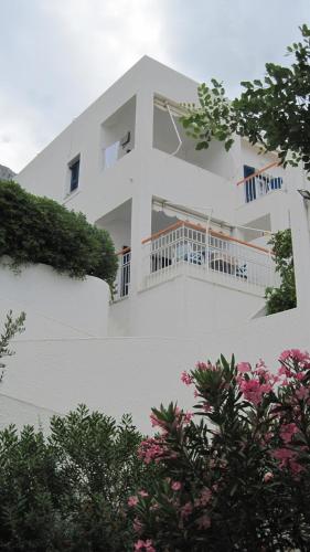 a white house with a balcony on the side of it at Tatsis Apartments in Masouri