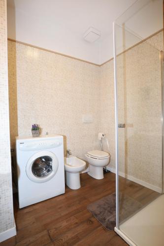 a bathroom with a washing machine and a toilet at Unique luxury apartment and rooms in Rome