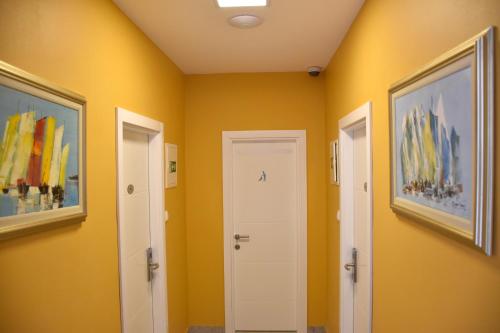 a hallway with two doors and yellow walls at Villa Riva in Makarska