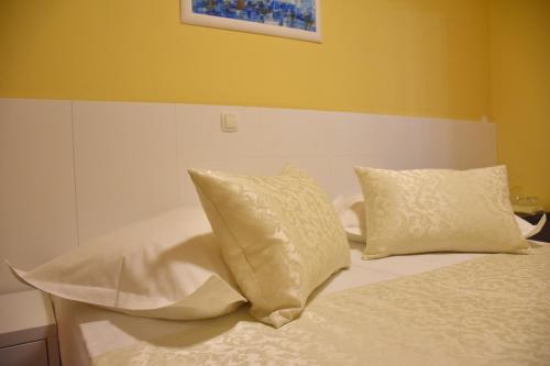 a bed with white pillows on it at Villa Riva in Makarska
