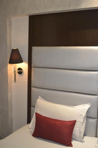a bedroom with a white bed with a red pillow at Southern Plaza in Kolkata
