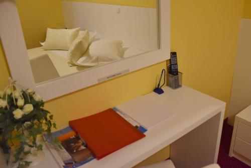 a mirror above a white desk with a bed in a room at Villa Riva in Makarska