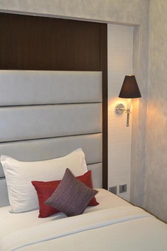 a bedroom with a white bed with red pillows at Southern Plaza in Kolkata