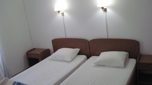 two beds in a small room with lights on the wall at Tatsis Apartments in Masouri