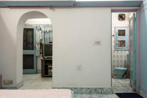 eine Küche mit einer weißen Wand und einem Torbogen in der Unterkunft Sangleela in Neu-Delhi