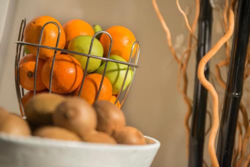 a bowl of fruit with oranges and kiwis at Locanda Giustini in Assisi