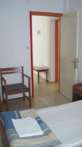 a room with a bed and a chair and a door at Tatsis Apartments in Masouri
