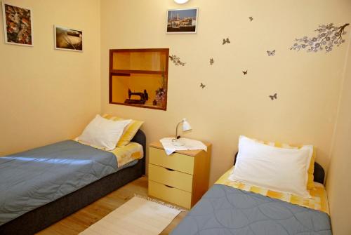 una camera con 2 letti e un comodino con lampada di Apartment Tina a Komiža