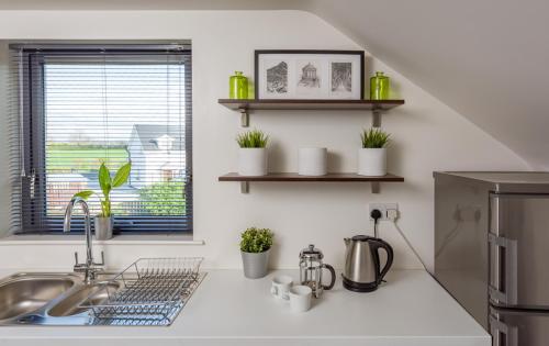 a kitchen counter with a sink and a window at Knockanboy Loft in Ballymoney