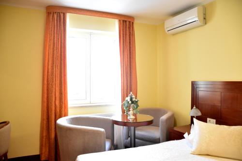 a room with a bed and a window with a table and chairs at Villa Riva in Makarska