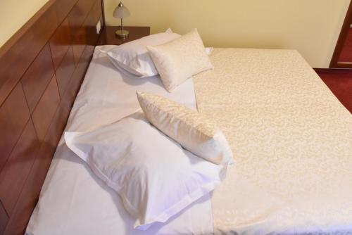a bed with white pillows on top of it at Villa Riva in Makarska