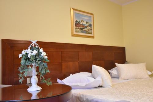 a bedroom with a bed and a vase with flowers on a table at Villa Riva in Makarska