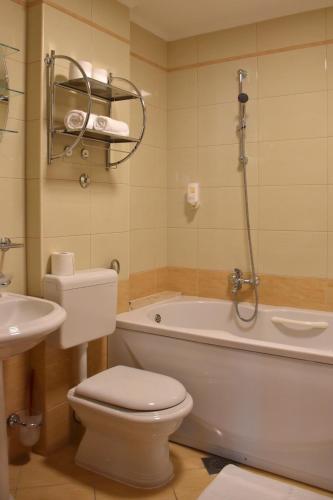 a bathroom with a tub and a toilet and a sink at Villa Riva in Makarska