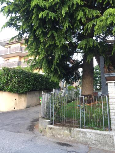 a fence in front of a tree next to a building at La Gufetta in Varese