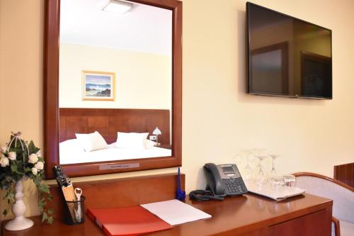 a mirror on a wall above a desk with a phone at Villa Riva in Makarska