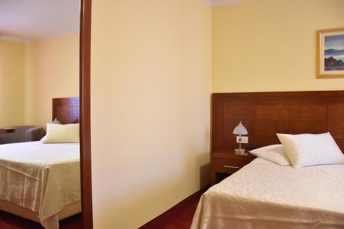 a hotel room with two beds and a mirror at Villa Riva in Makarska