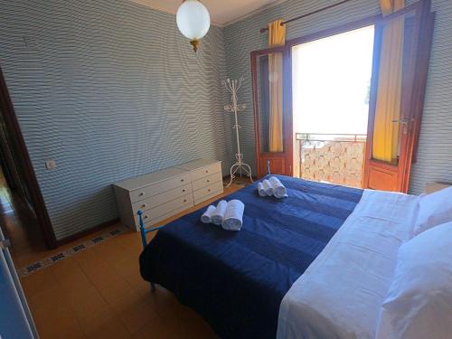 a bedroom with a blue bed with towels on it at Ammiraglio in Campese