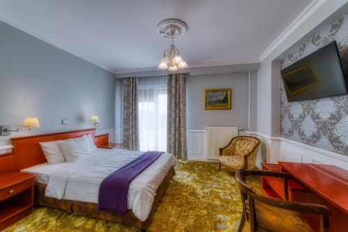 a hotel room with a bed and a desk at Grand Częstochowa in Częstochowa