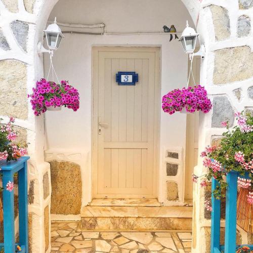 una porta bianca con fiori viola davanti di Bodrum Sade Pension a Bodrum City