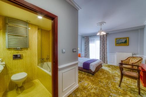 a bathroom with a bed and a toilet and a sink at Grand Częstochowa in Częstochowa