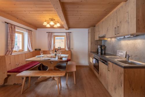 a kitchen with wooden cabinets and a wooden table at Berggasthof Staudachstub'n in Kirchberg in Tirol