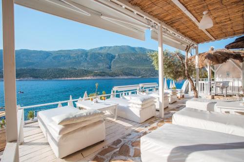 a patio with white furniture and a view of the water at Club Çapa Hotel in Kas