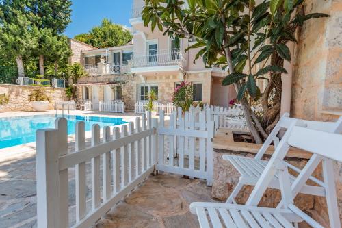 a villa with a swimming pool and a white fence at Club Çapa Hotel in Kas
