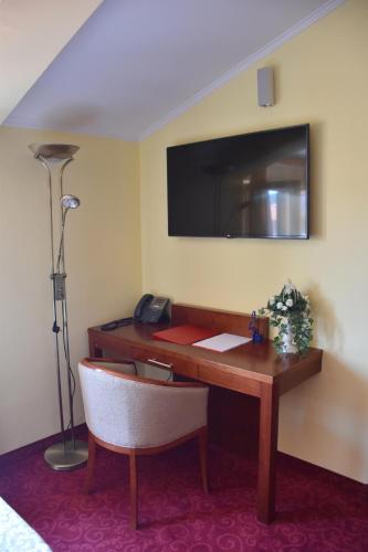 a room with a desk with a lamp and a television at Villa Riva in Makarska