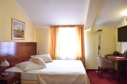 a bedroom with a bed and a desk and a window at Villa Riva in Makarska