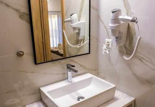 a bathroom with a sink and a mirror at Island Dreams Rooms & Suites in Rhodes Town