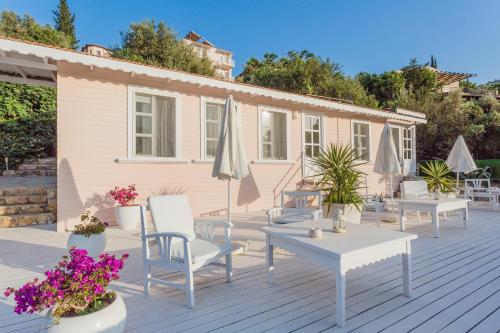 a deck with chairs and tables and umbrellas at Club Çapa Hotel in Kas