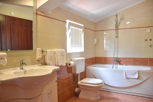 a bathroom with a tub and a toilet and a sink at Villa Riva in Makarska