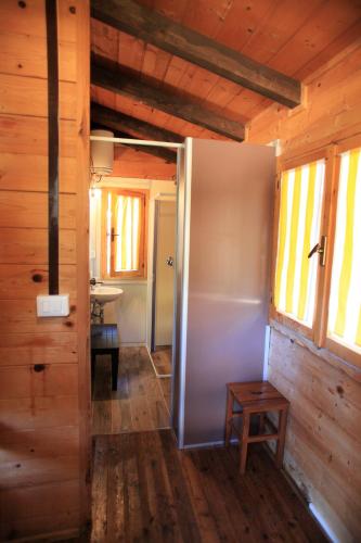 an open door to a bathroom in a wooden cabin at Camping Bella Sardinia in S'archittu Cuglieri