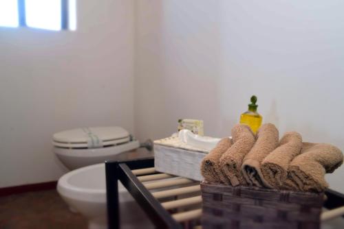 a bathroom with a toilet and a sink and towels at I Dammusi Sapori di Pantelleria in Pantelleria