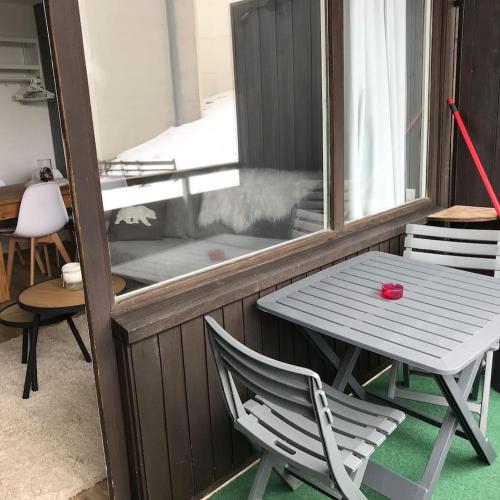 a white table and a chair on a balcony at Charmant studio cabine COCOON à 100 m des pistes in Chamrousse