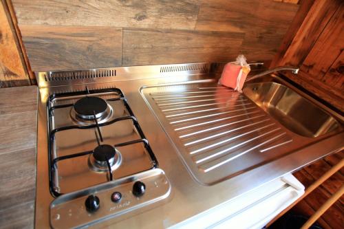 a stove top oven with a red box on it at Camping Bella Sardinia in S'archittu Cuglieri