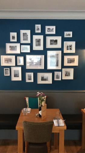 a dining room with a table and pictures on the wall at Strawberry Bank Hotel, NEC in Meriden