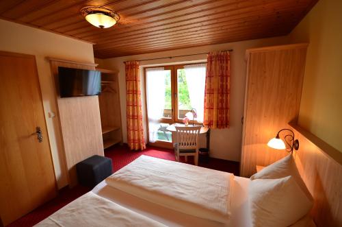 ein Hotelzimmer mit einem Bett und einem Fenster in der Unterkunft Gästehaus Sonnenbichl in Fischbachau
