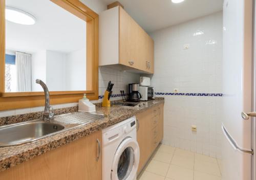 a kitchen with a sink and a washing machine at Apartamentos Varadero Sea View in Cala del Moral