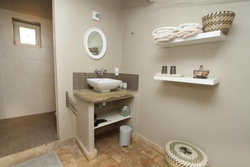 une salle de bain avec un lavabo et un miroir dans l'établissement Le Mas du Père Jean, à Roche-Saint-Secret