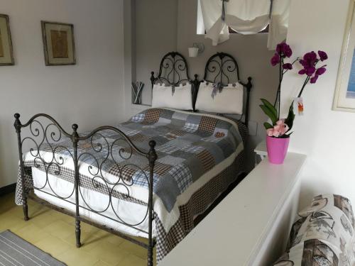 ein Schlafzimmer mit einem schwarzen Bett mit Blumen in einer Vase in der Unterkunft Fattoria del pino in Miasino